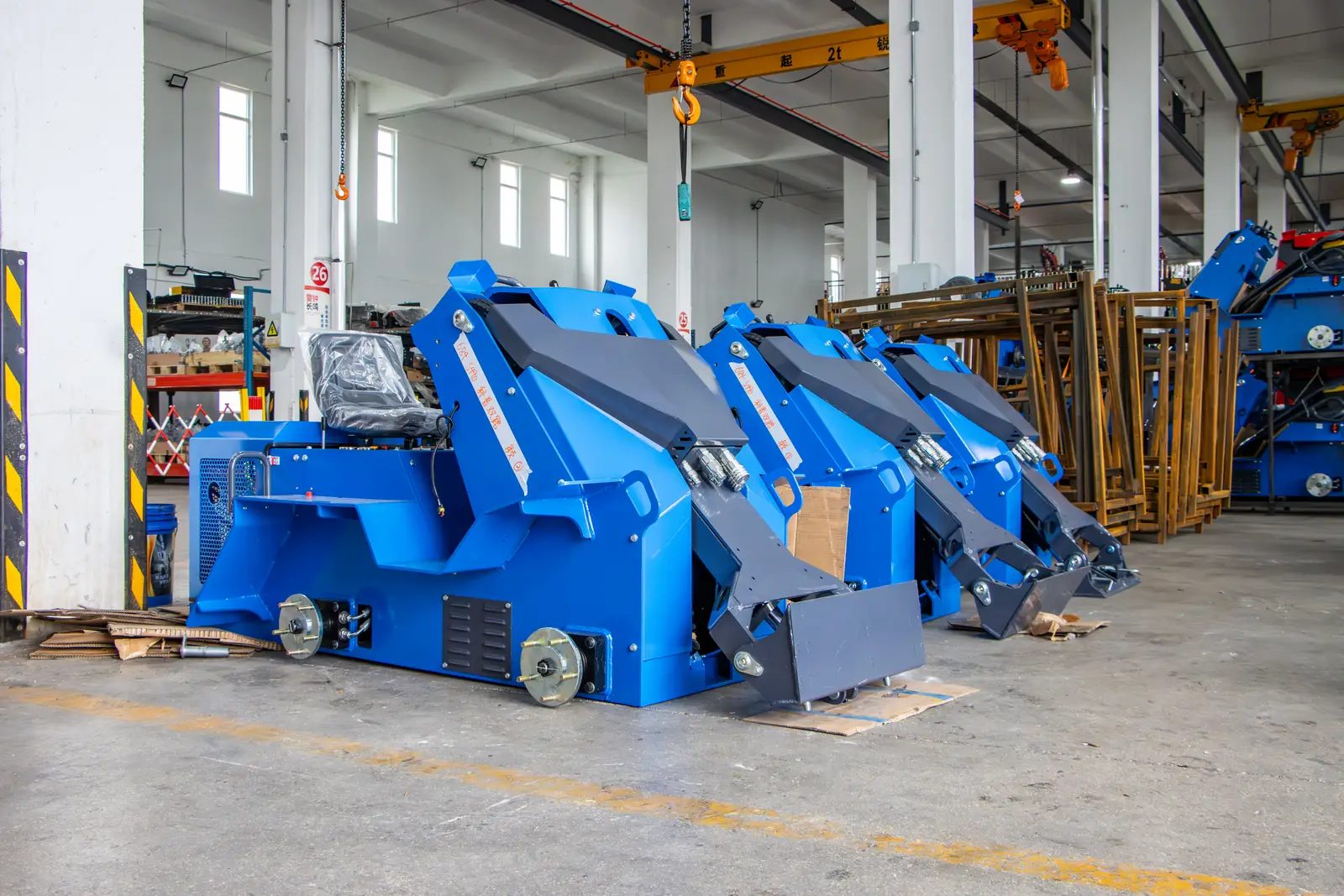 Seated loader frames painted blue for a customer order, waiting for assembly