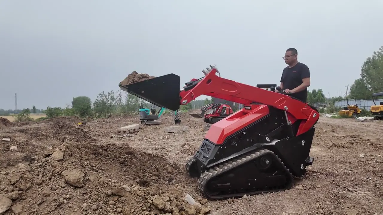 Red BL-T1000-H tracked mini skid steer loader on bare, rough ground, lift arms raised with a bucket full of soil, the operator standing on the rear platform